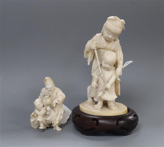 A Meiji carved ivory group of two children (damaged) on hardwood stand and a smaller group tallest 14cm incl. stand